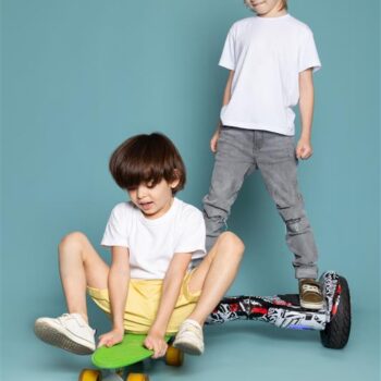 front-view-two-boys-adorable-sweet-cute-happy-riding-scooter-segway-blue-floor